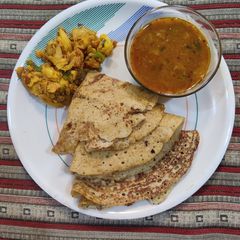 A picture of Bajra moong urad dal masala dosa and sambhar.