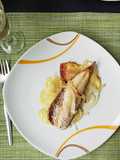 Verdel al horno con guarnición de patata panadera y cebolla