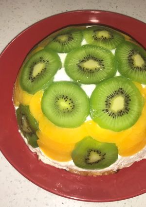 Una foto de Postre invertido de kiwis y duraznos