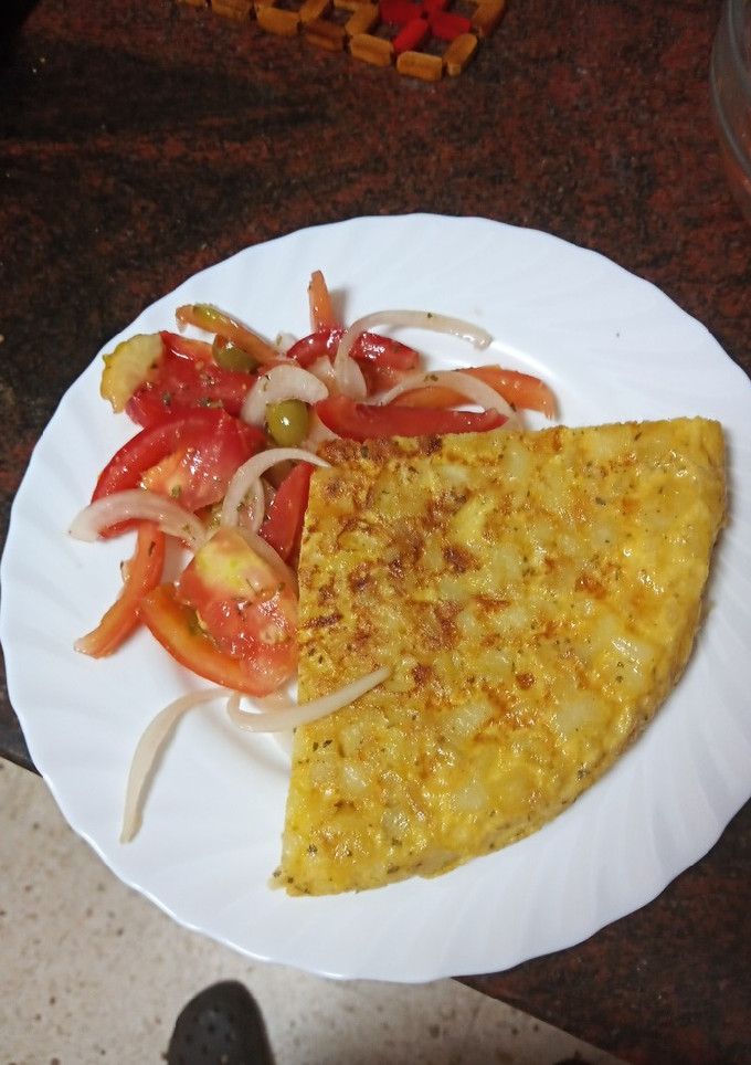 Una foto de Tortilla de papas con cebolla y ensalada de tomate