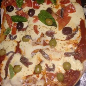 Pizza integral tomate anchoas, olivas y albahaca