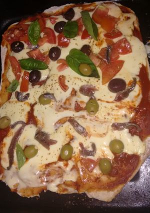 Una foto de Pizza integral tomate anchoas, olivas y albahaca