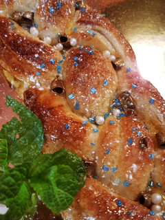 Una foto de Trenza de hojaldre rellena de yema pastelera y uvas pasas