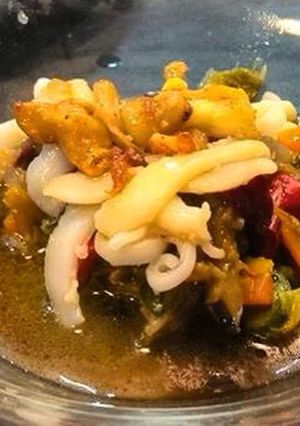 Una foto de Caldo de sepia con sus verduras tiras y dos texturas de sepia, salteadas y crujientes