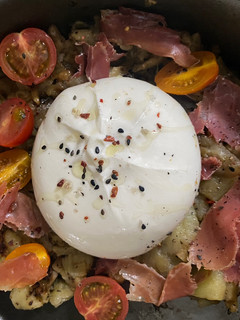 Una foto de Berenjena al horno con tomates cherry, jamón serrano y burrata