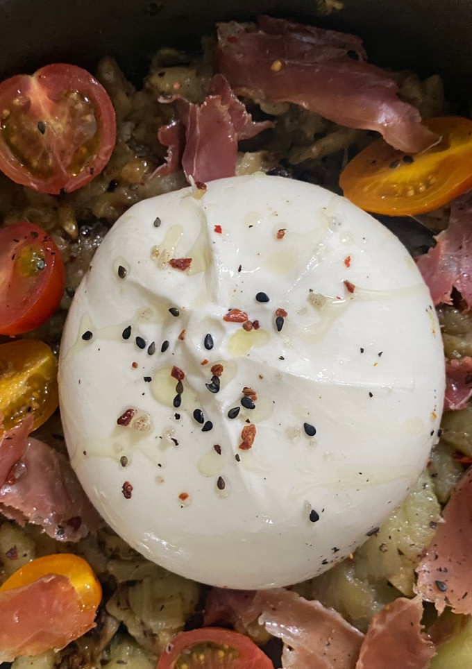 Una foto de Berenjena al horno con tomates cherry, jamón serrano y burrata
