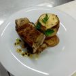 Costilla de cerdo y vacuno emulsionada en salsa de maracuyá acompañada de puré de habas envuelto en masa filo gratinado sobre papas al romero