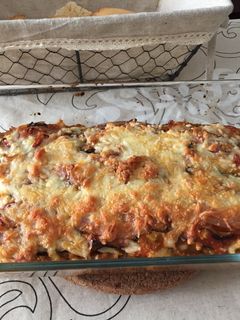 Una foto de Lasaña de berenjena rellena de carne y rulo de cabra con topping de bacon y 4 quesos