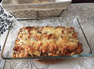 Una foto de Lasaña de berenjena rellena de carne y rulo de cabra con topping de bacon y 4 quesos