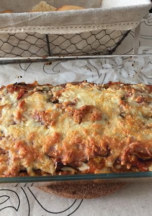 Una foto de Lasaña de berenjena rellena de carne y rulo de cabra con topping de bacon y 4 quesos