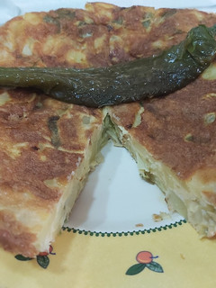 Una foto de Tortilla de patatas rellena de pimientos fritos