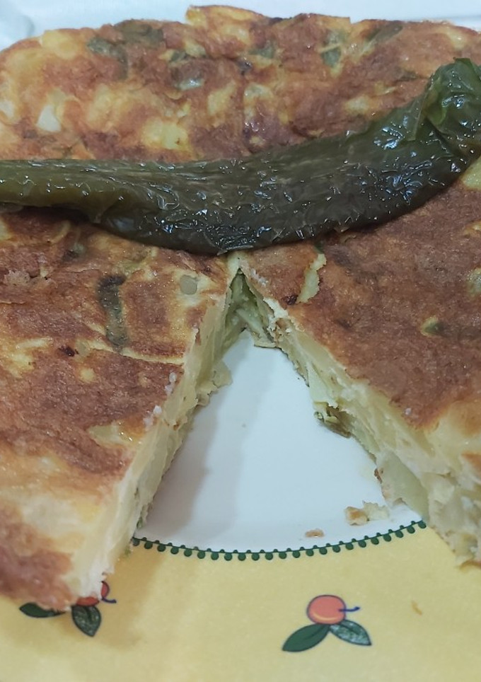 Una foto de Tortilla de patatas rellena de pimientos fritos