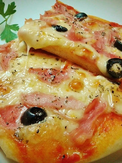 Una foto de Pizza prosciutto con aceitunas negras