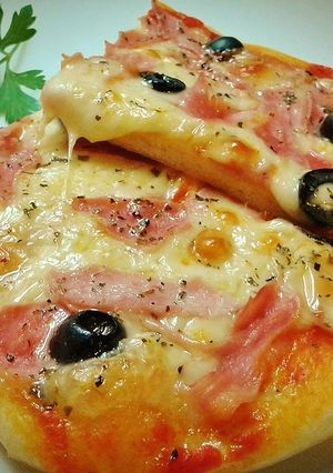 Una foto de Pizza prosciutto con aceitunas negras