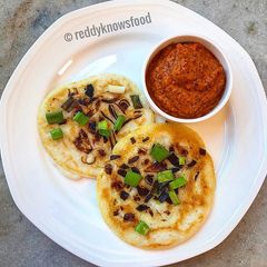 A picture of Crispy shallots Uthappam with spicy tomato garlic chutney.