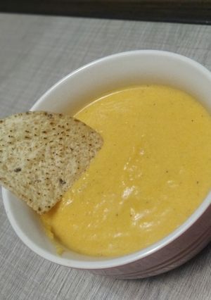 Una foto de Nachos con salsa de calabaza y queso cheddar