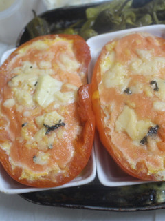 Una foto de Tomate relleno de surimi acompañado de pimientos de Padrón