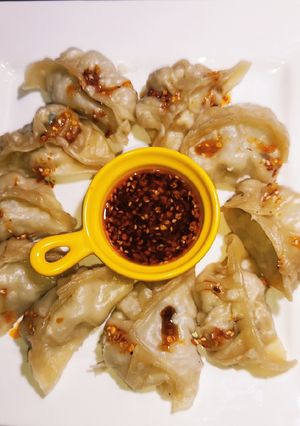 A picture of Dumplings or Momos Served With Chilli Oil.
