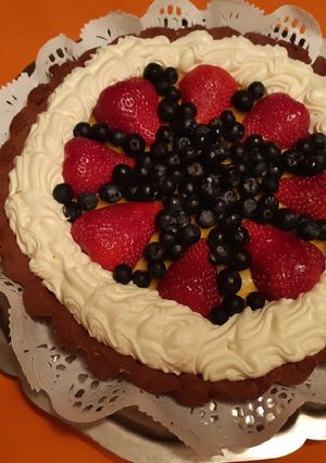 Una foto de Tarta de maracuyá y chocolate con frutos rojos
