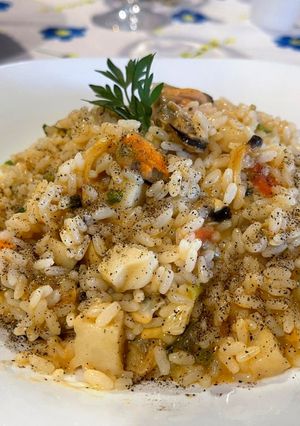 A picture of Risotto with Mussels, Clams, Squid, and Fresh Cherry Tomatoes.