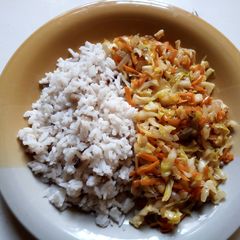 A picture of Rice and beans with cabbage and carrots sauce.