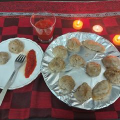 A picture of Chicken momos with spicy sauce.