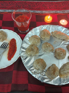 A picture of Chicken momos with spicy sauce.