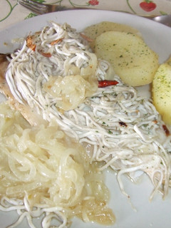 Una foto de Lubina con cebolla caramelizada, gulas y patatas al perejil