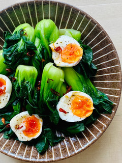 A picture of Bok Choy with jammy eggs.