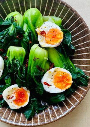 A picture of Bok Choy with jammy eggs.