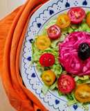 Ensalada multicolor sobre base de lechuga capuchina 💚 con cherry ♥️ 💛 más cebolla morada encurtida 💜