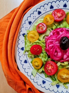Una foto de Ensalada multicolor sobre base de lechuga capuchina 💚 con cherry ♥️ 💛 más cebolla morada encurtida 💜
