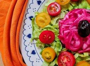 Una foto de Ensalada multicolor sobre base de lechuga capuchina 💚 con cherry ♥️ 💛 más cebolla morada encurtida 💜