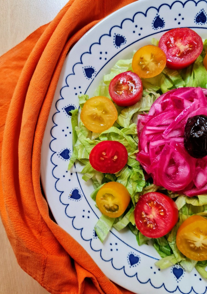 Una foto de Ensalada multicolor sobre base de lechuga capuchina 💚 con cherry ♥️ 💛 más cebolla morada encurtida 💜