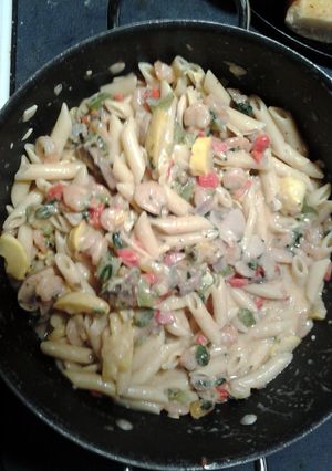 A picture of garden fresh penne pasta with shrimp.