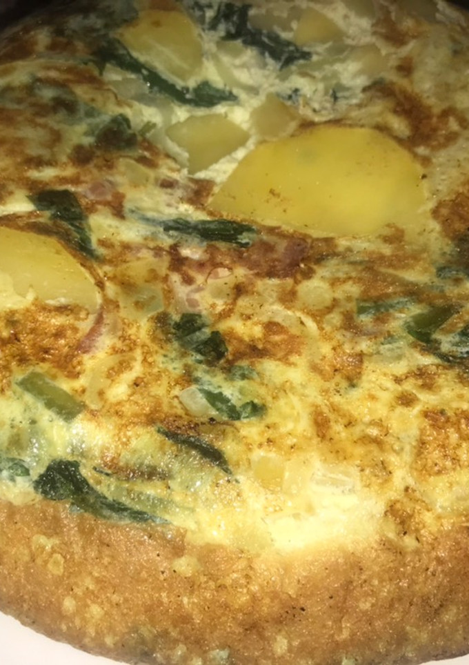 Una foto de Tortilla de papa, cebolla, espinaca y tocineta