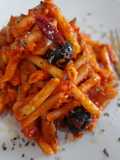 Macarrones con salchichas y olivas negras en salsa de tomate