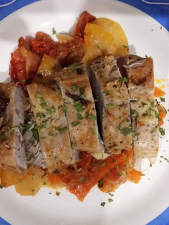 Una foto de Solomillo de cerdo al horno en cama de verduritas a la mantequilla y tomate