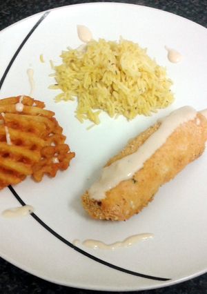 A picture of chicken roll with a cream spiced fillin, paprika rice, crispy potato slice & four cheese sauce.
