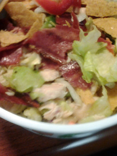A picture of taco salad with chicken and turkey bacon.