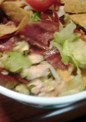 A picture of taco salad with chicken and turkey bacon.