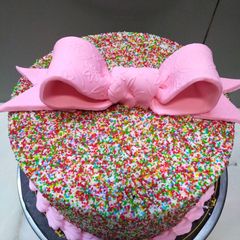 A picture of Bow on top full cover sprinkles cake 🎀.