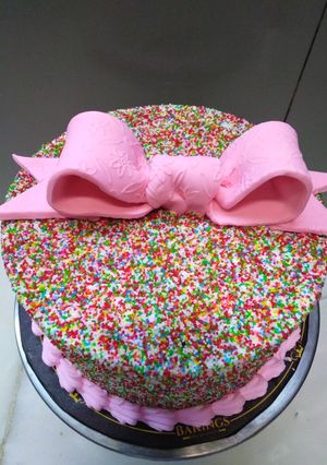 A picture of Bow on top full cover sprinkles cake 🎀.