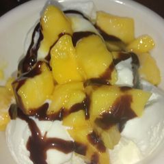 A picture of Vanilla ice cream with chocolate and mango.