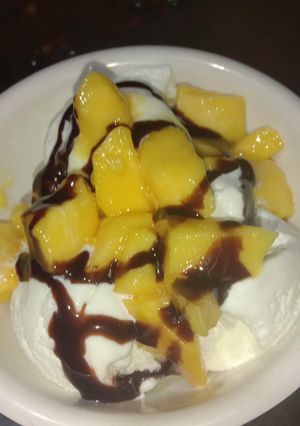 A picture of Vanilla ice cream with chocolate and mango.