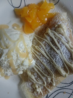 Una foto de Crepes dulces con durazno, dulce de leche y helado