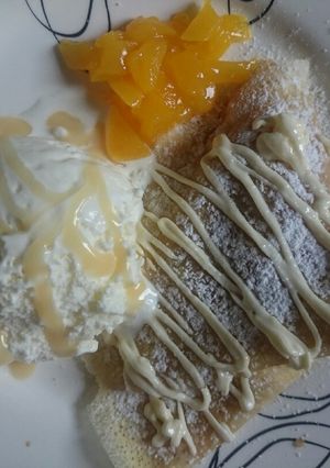 Una foto de Crepes dulces con durazno, dulce de leche y helado