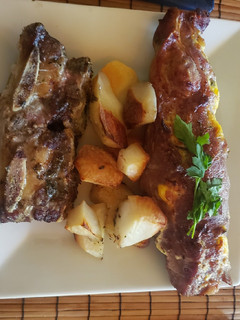 Una foto de Bondiola rellena, con papas sazonadas al horno! Plus de asado