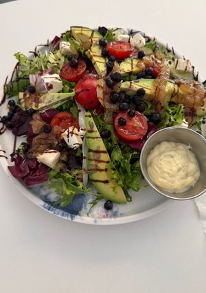 Una foto de Ensalada templada con aguacate, queso y cebolla caramelizada