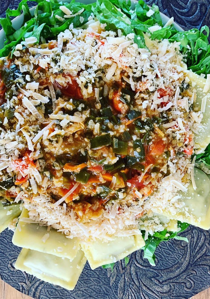 Una foto de Ravioles con salsa de tomate sobre colchón de lechuga
